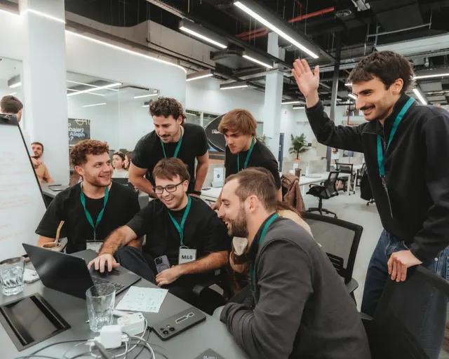 Un equipo festeja frente a la laptop en La Mesa de Mate & Build, con Franco a la derecha